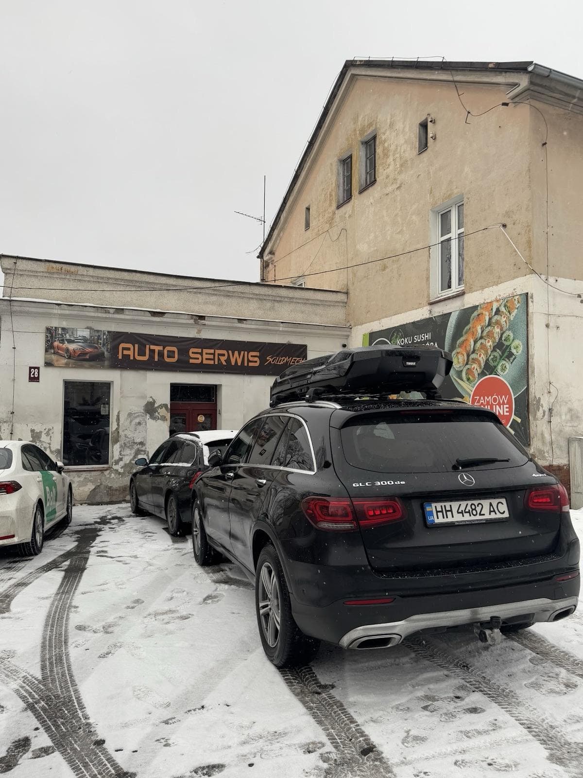 Front warsztatu SolidMech przy Wolności 28 w Jeleniej Górze, szyld Auto Serwis, auta na placu zimą