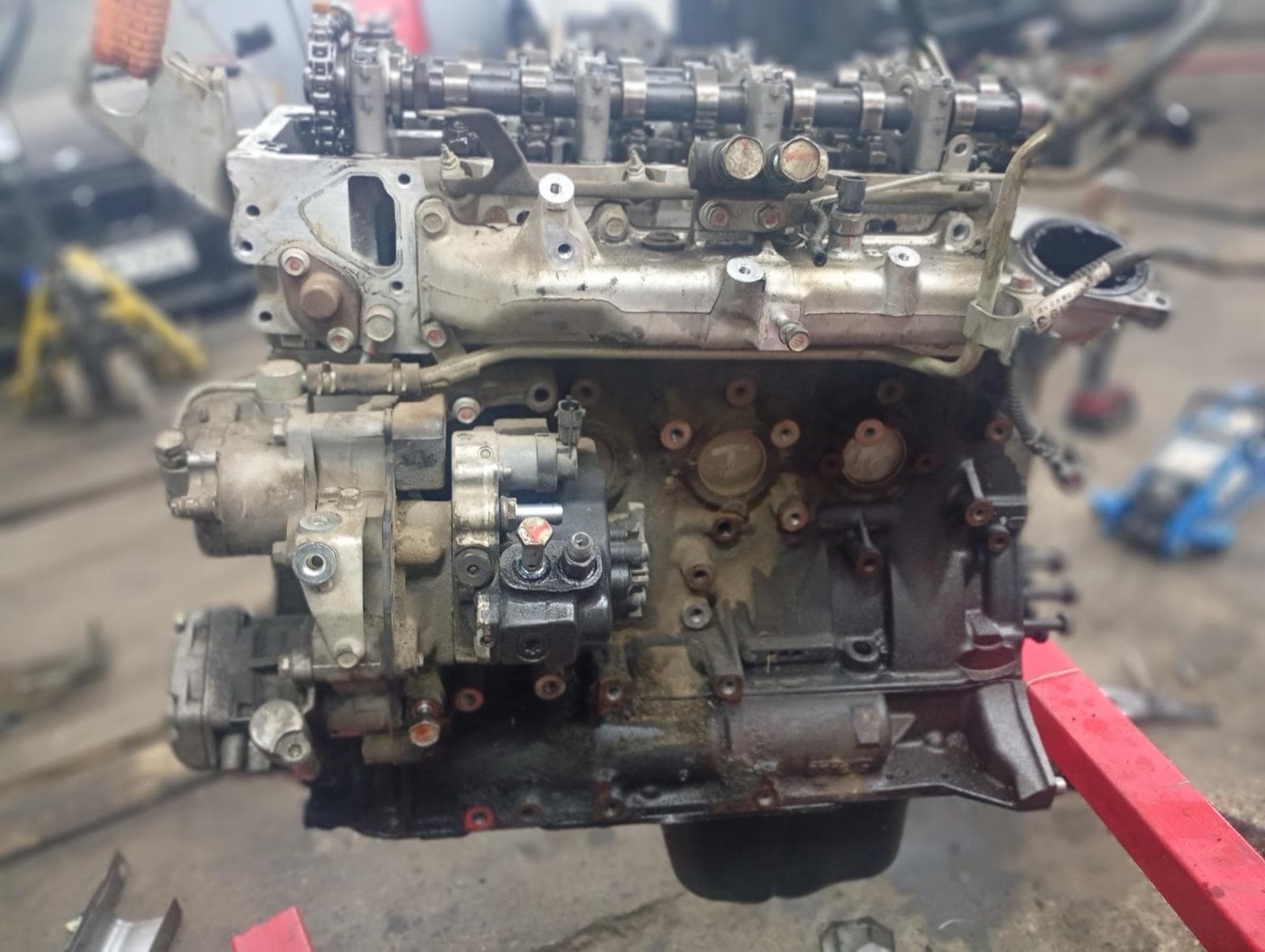 Silnik na stojaku warsztatowym w hali SolidMech, w tle auto na podnośniku